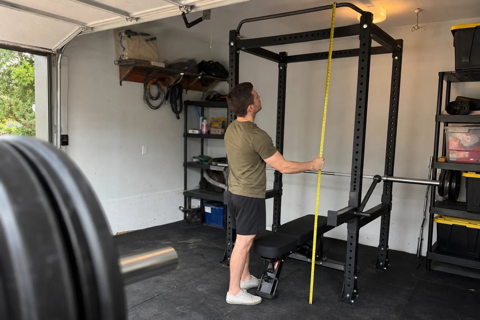 Home gym buyer measuring power rack height in an ordinary garage